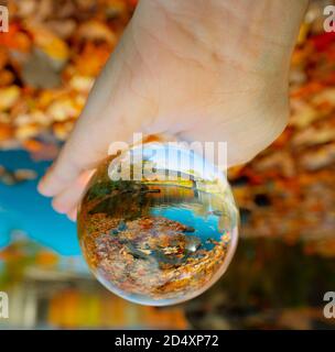 Crystal ball niché dans la paume d'une main, reflétant un pont couvert dans le Maine. Banque D'Images