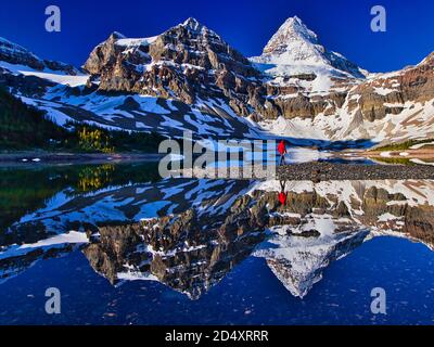 Randonneur marchant le long du lac Magog avec le mont Assiniboine en arrière-plan, Colombie-Britannique, Canada Banque D'Images