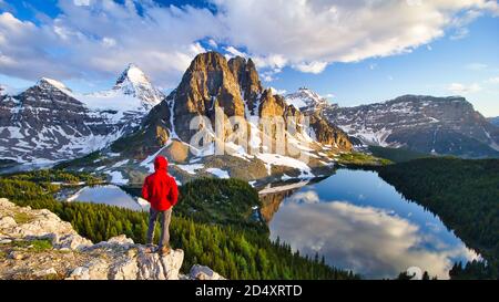 Personne randonneur surplombant le mont Assiniboine avec les lacs Magog, Sunburst et Ceruléen, vu de Nub Peak, Colombie-Britannique, Canada Banque D'Images