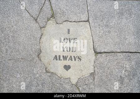 Je vous aime toujours des mots écrits sur un trottoir en béton. Estampiller sur le sol Banque D'Images