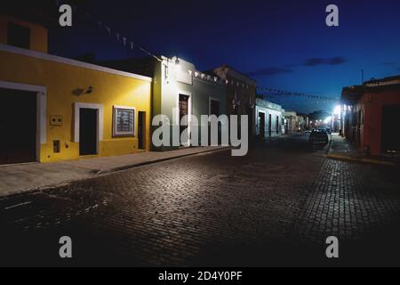 Rue traditionnelle du dôme mexicain avec bâtiments coloniaux et petits drapeaux blancs dans la nuit, Merida, Yucatan, Mexique Banque D'Images