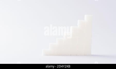 Graphique des piles ascendantes de cubes de sucre, prise studio isolée sur fond blanc, santé risque élevé de diabète de sang concept Banque D'Images