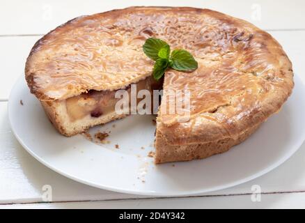 Tarte traditionnelle aux pommes maison aux canneberges. Gâteau complet sur une table blanche en bois Banque D'Images