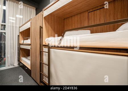 Russie, Moscou - novembre 26 2018. Dites hôtel génial. Le dortoir de l'hôtel dispose de plusieurs lits disposés dans une chambre. Propre auberge petite chambre avec des lits superposés en bois. Banque D'Images