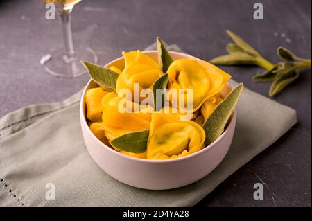 Tortelloni à la sauge aromatique, à la ricotta et aux épinards. Pâte d'œufs italienne et vin blanc. Cuisine traditionnelle de Bologne, région de l'Émilie-Romagne. Gros plan. Photo de haute qualité Banque D'Images