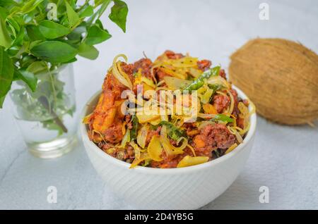 Délicieux poulet frite à la noix de coco dans un bol blanc avec une noix de coco entière Banque D'Images