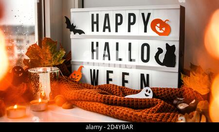 JOYEUX HALLOWEEN. Texte en boîte blanche, avec un fond de chandail, feuilles séchées halloween décoration d'automne sur le rebord de la fenêtre. Fenêtre de pluie Banque D'Images