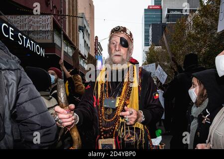 Un manifestant portant des vêtements chamaniques participe au rassemblement Black Lives Matter.des milliers de personnes se sont rassemblées au Parlement victorien et dans des villes du pays pour protester contre la mort de George Floyd à Minneapolis en garde à vue. De nombreux manifestants à Melbourne portaient des masques et utilisaient un désinfectant pour les mains car des restrictions de la phase 3 de la classe 19 étaient en place. Après des discours au Parlement, les manifestants ont marché paisiblement jusqu'à la gare de Flinders Street, où ils se sont rassemblés à l'intersection alors que la nuit tombait. Banque D'Images