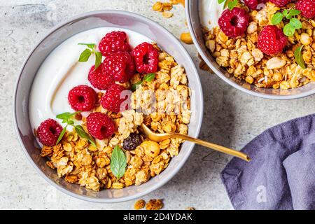 Muesli avec framboises et yaourt dans un bol gris. Concept alimentaire sain. Banque D'Images