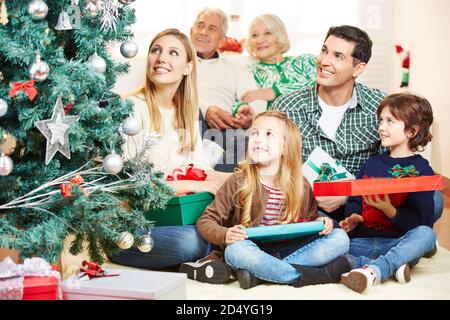 Une famille heureuse regarde ensemble l'arbre de Noël à Noël Banque D'Images