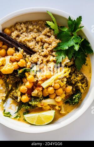Curry de pois chiches vegan avec chou-fleur, brocoli, chou frisé et quinoa. Concept de nourriture végétarienne saine. Banque D'Images