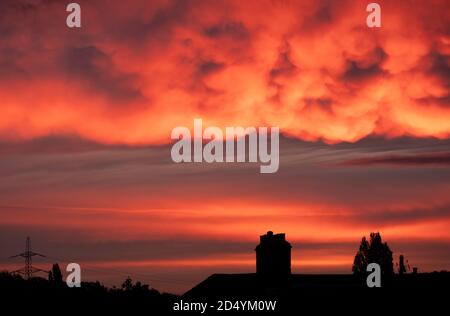 Météo au Royaume-Uni : 12 octobre 2020. Des nuages spectaculaires et colorés illuminés par le soleil levant au-dessus des toits de Londres SW19, Royaume-Uni Banque D'Images