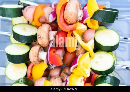 Brochette de légumes prête à être grillée sur un barbecue à gaz extérieur. Banque D'Images