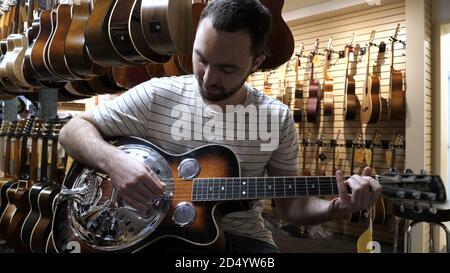 Montréal, Québec, Canada - 25 juin 2018 : Guy jouant de la guitare dans une boutique de guitare. Banque D'Images