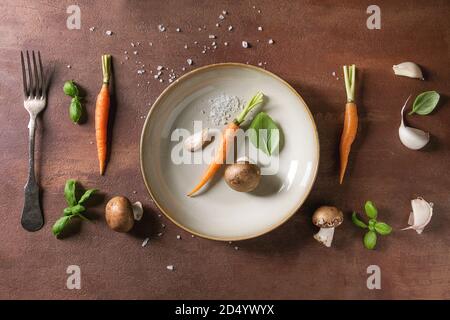 Variété de fines herbes de cuisine avec mini carottes et champignon champignons en ligne sur fond de marbre blanc. Mise à plat, de l'espace. Concept de cuisine, de l'alimentation Banque D'Images