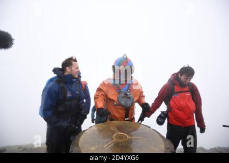Le collecteur de fonds vétéran Lloyd Scott, qui tente de grimper les trois sommets en aide à la charité de Lord's Taverners tout en portant un costume de plongée en haute mer, atteint le sommet du mont Snowdon à Snowdonia, au nord du pays de Galles. Banque D'Images