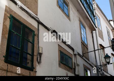 La maison de ville se trouve dans une rue étroite de Saint-Jacques-de-Compostelle, en Espagne, par une chaude journée ensoleillée. Architecture fenêtres fenêtres cadres de fenêtre vieux de pierre. Banque D'Images