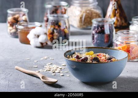 Variété de fruits secs, noix, miel et flocons d'avoine dans un bol et différents pots de verre pour la cuisson des petit-déjeuner sain ou muesli muesli énergie b Banque D'Images