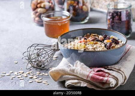 Variété de fruits secs, noix, miel et flocons d'avoine dans un bol et différents pots de verre pour la cuisson des petit-déjeuner sain ou muesli muesli énergie b Banque D'Images