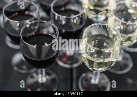 Verres à vin rouge et blanc disposés sur un noir brillant tableau Banque D'Images
