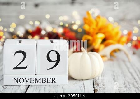 Blocs de calendrier en bois blanc avec date du 29 novembre et décorations d'automne sur une table en bois. Mise au point sélective avec arrière-plan flou. Banque D'Images