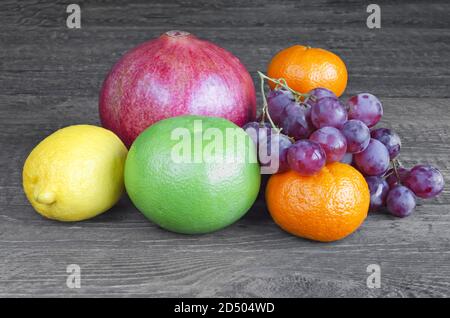 Différents fruits sur une table en bois gris Banque D'Images