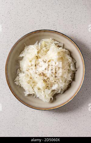 Choucroute chou blanc haché mariné dans la saumure avec le cumin dans une plaque en céramique sur gray background. Mise à plat, de l'espace Banque D'Images