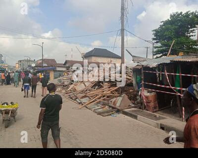 Lagos, Nigéria. 12 octobre 2020. Les gens de la région passent le site d'un incident d'effondrement de bâtiment à Lagos, au Nigeria, le 12 octobre 2020. Le nombre de morts d'un bâtiment de trois étages qui s'est effondré ici dimanche s'est élevé à sept alors que les autorités intensifiaient les efforts de recherche et de sauvetage. Credit: Tope Ayoku/Xinhua/Alamy Live News Banque D'Images