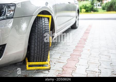 Fixation de roue jaune sur une voiture garée illégalement Banque D'Images