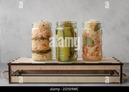 divers choux fermentés et concombres en pots sur une boîte en bois. fond gris, image horizontale Banque D'Images