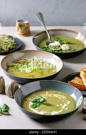 Variété de légumes vert asperges, brocoli, pois et décoré par les verts, légumes, œufs de caille, crème, huile d'olive, de bols de céramique plus de Gray Banque D'Images