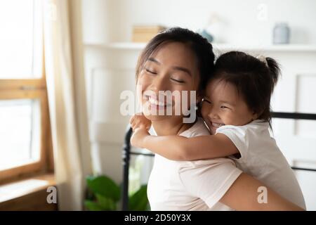 Gros plan une mère asiatique souriante qui soutient la petite fille Banque D'Images