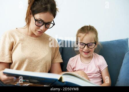 Mère et fille lisent un livre. Mère enseigne une petite fille. Banque D'Images