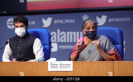 New Delhi, Inde. 12 octobre 2020. Le ministre des Finances et des Corporations, Nirmala Sitharaman, porte un masque lors d'une conférence de presse pour annoncer la création d'une crte RS 73,000 afin de stimuler les dépenses des consommateurs dans l'économie pour relancer l'économie dans le but de lutter contre le ralentissement dû à la pandémie de Covid-19, En tant que ministre d'État aux Finances, Anurag Thakur la regarde. Crédit : SOPA Images Limited/Alamy Live News Banque D'Images