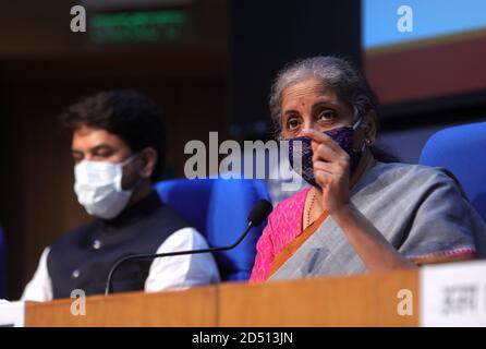 New Delhi, Inde. 12 octobre 2020. Le ministre des Finances et des Corporations, Nirmala Sitharaman, porte un masque lors d'une conférence de presse pour annoncer la création d'une crte RS 73,000 afin de stimuler les dépenses des consommateurs dans l'économie pour relancer l'économie dans le but de lutter contre le ralentissement dû à la pandémie de Covid-19, En tant que ministre d'État aux Finances, Anurag Thakur la regarde. Crédit : SOPA Images Limited/Alamy Live News Banque D'Images