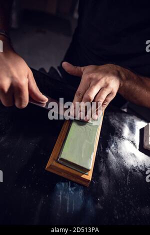 L'homme qui utilise la pierre à affûter Banque D'Images