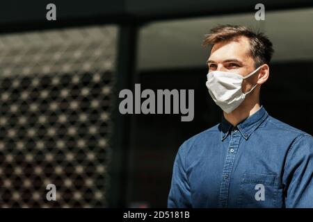 blogueur mâle dans un masque de protection en utilisant un ordinateur portable dans la rue . Banque D'Images