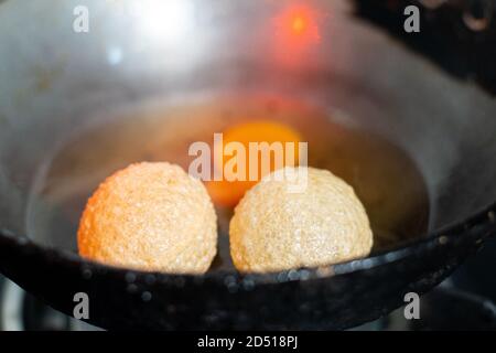 photo de la petite cuisine de rue du nord de l'inde ged gappe pani puri ou puchke frits à partir de la pâte dans de l'huile chaude pour les faire ronds sphères de boule dorée creuses Banque D'Images