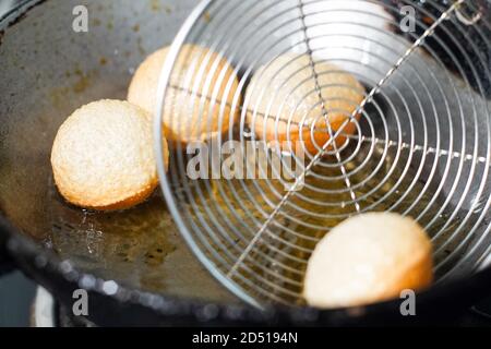 photo de la petite cuisine de rue du nord de l'inde ged gappe pani puri ou puchke frits à partir de la pâte dans de l'huile chaude pour les faire ronds sphères de boule dorée creuses Banque D'Images