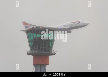 Journée d'adieu pour les avions de ligne Boeing 747 Jumbo Jet de British Airways après le ralentissement du voyage de la COVID-19. G-CIVY survolant la tour de contrôle dans un ciel sombre Banque D'Images
