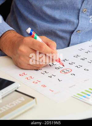 L'homme a marqué le 13e jour sur le calendrier, l'arrière-plan du bureau. Vendredi 13, la date de superstition, encerclé avec le stylo rouge dans le planificateur. Gros plan, Banque D'Images