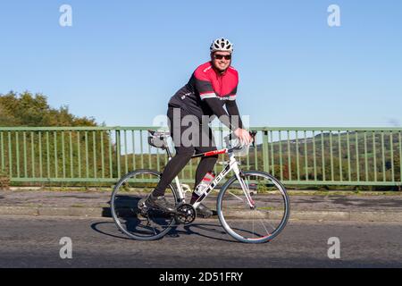 Cycliste de sport en fibre de carbone vélo de route sur la route de campagne traversant le pont d'autoroute dans la campagne du Lancashire, Royaume-Uni Banque D'Images