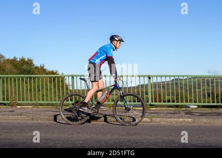 Cycliste de sport en fibre de carbone vélo de route sur la route de campagne traversant le pont d'autoroute dans la campagne du Lancashire, Royaume-Uni Banque D'Images