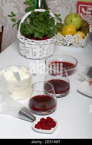Cuisine du fromage à la crème avec gelée de framboise. Décoration avec biscuits, framboises et menthe. Banque D'Images