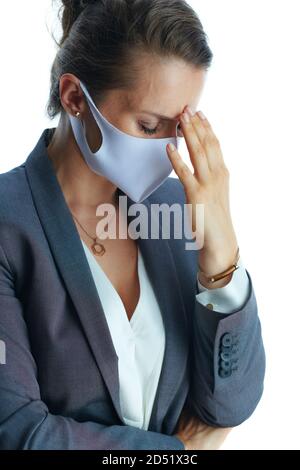 Les affaires pendant la pandémie de coronavirus. Femme moderne stressée en costume gris avec masque médical isolé sur fond blanc. Banque D'Images