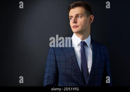 jeune homme d'affaires sérieux en chemise de costume noir classique posant isolé sur fond noir, réalisation carrière richesse concept d'affaires, tournage en studio Banque D'Images