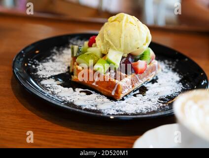 Glace vanille aux fruits rouges, fraises, bleuets, framboises, pomme sur gaufre avec du sucre en poudre. Concept de l'alimentation d'été Banque D'Images