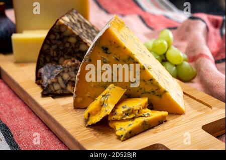 Fromages britanniques et irlandais, assiette de dégustation avec shropshire bleu, fromage de portier brun et cheddar fumé Banque D'Images