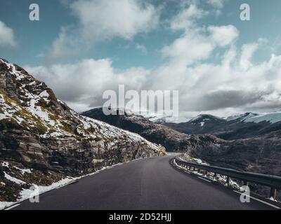 Norvège, route étroite et sinueuse vide jusqu'au sommet de la montagne Dalsnibba avec de la neige sur le côté de la route Banque D'Images