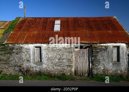 Ancienne maison en pierre,hangar,Outhouse,délabré,decorpit,Red rouillé toit galvanisé,tôle,rustique,porte en bois,porte en bois,RM Irlande Banque D'Images